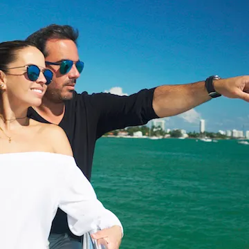 a man and a woman standing on a boat on the water