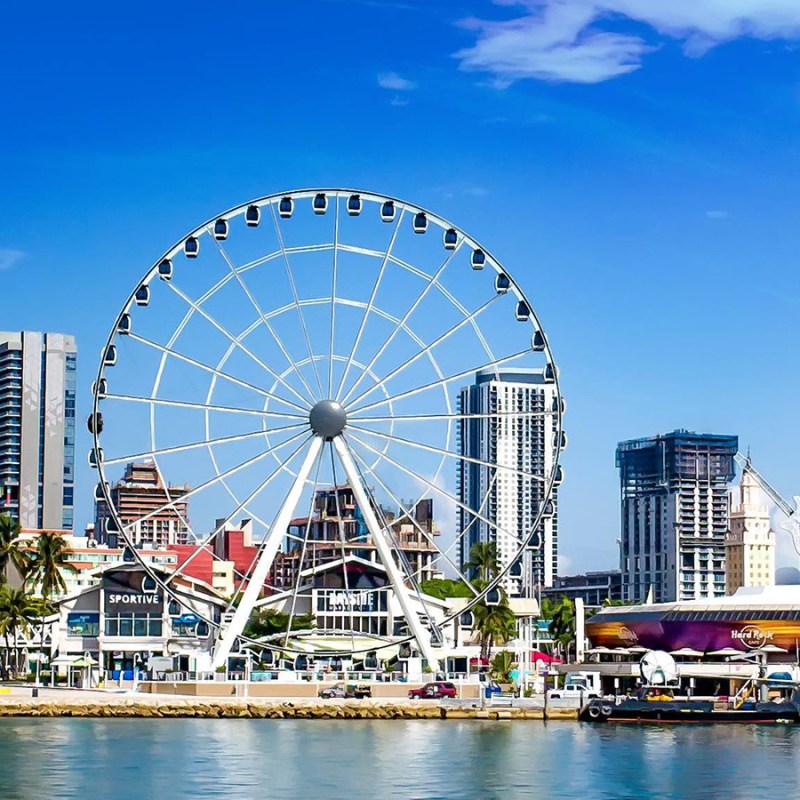 a large ship in a body of water with a city in the background