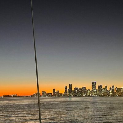 a sunset over a body of water with a city in the background