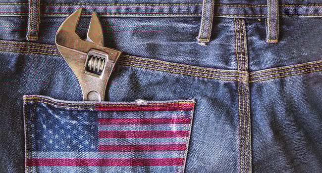 Wrench in a jean pocket with an American flag design.