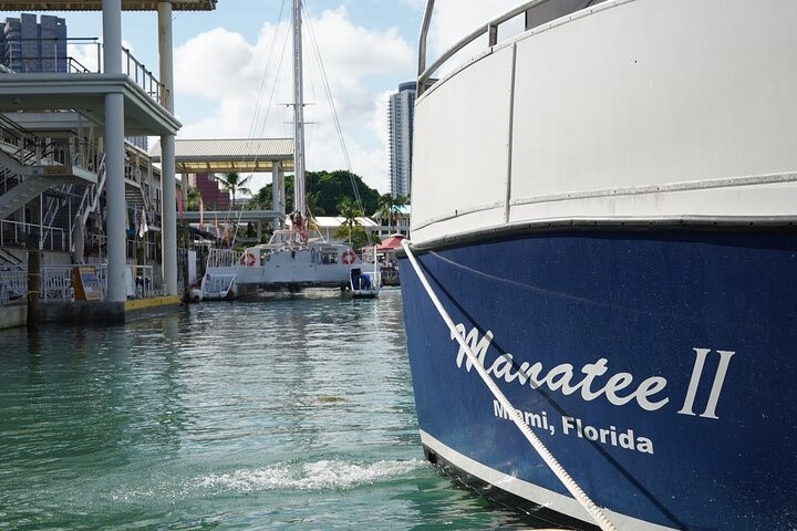 Boat named 'Manatee II' docked in Miami, Florida with buildings and another boat in the background.