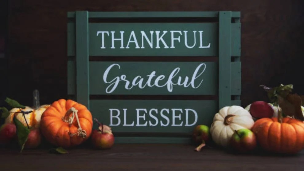 Sign reading 'Thankful Grateful Blessed' with pumpkins and apples around it.