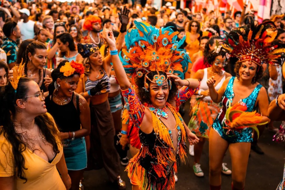 People in colorful costumes dancing and celebrating at a lively street festival.