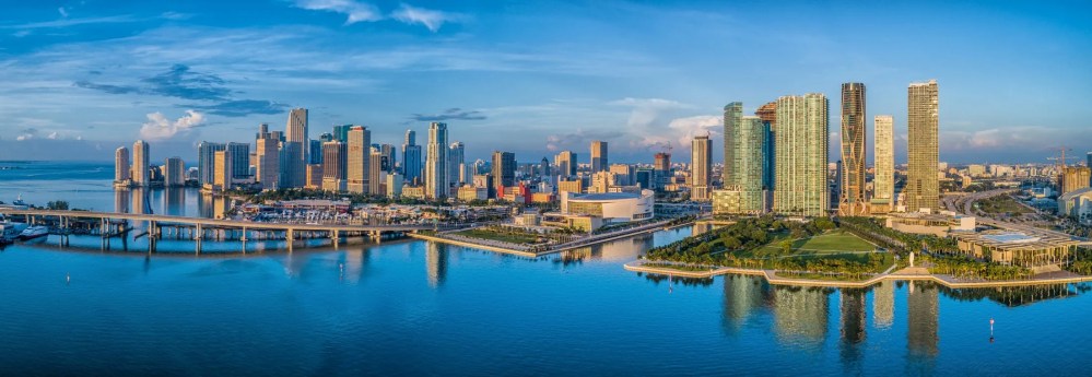 Panoramic view of Miami skyline with high-rise buildings and waterfront.